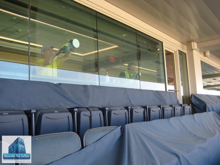 Scratched Curtainwall Resurfacing Notre Dame Football Stadium Richard Evans and union helper resurfacing tempered glass panels inside Notre Dame Stadium, viewed from exterior looking through glass