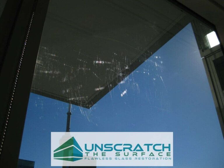 Glass Scratch Removal Toronto Canada - Commercial High-rise Shangri-La Toronto scratched tempered glass visible in sunlight with CN Tower in background
