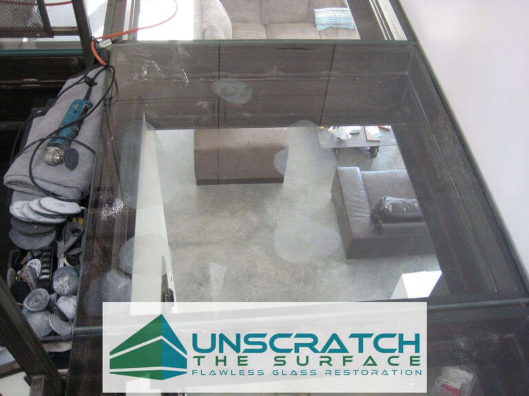Using small makita to fix scratches in glass floor.